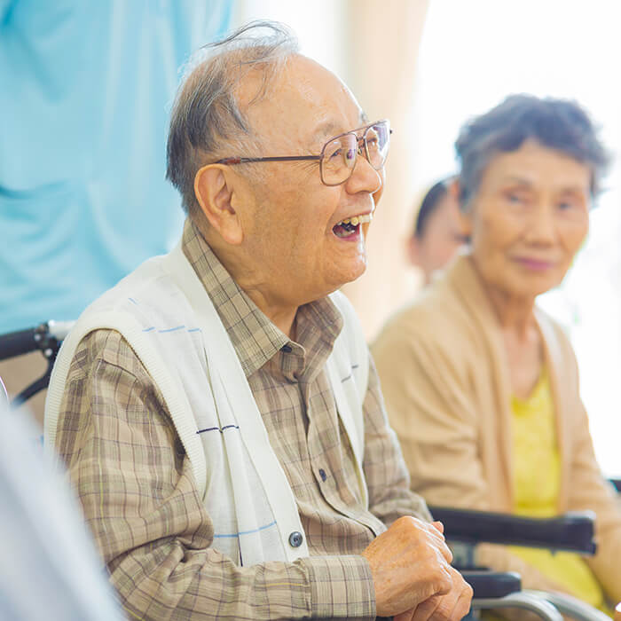 車椅子に座って笑顔を見せる入居者