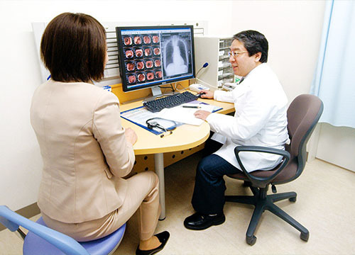 医師がモニターの画像を見せながら患者に説明している様子